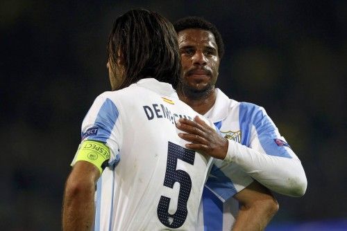 Malaga's Eliseu consoles team mate Demichelis after defeat to Borussia Dortmund  in Champions League quarter-final second leg soccer match against Borussia Dortmund in Dortmund