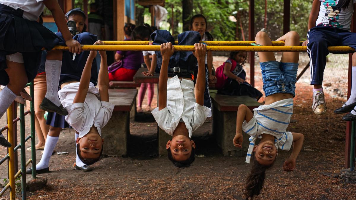 Fotografía de la exposición ‘Acá y Allá’, donde unos escolares nicaragüenses juegan en el patio de su colegio