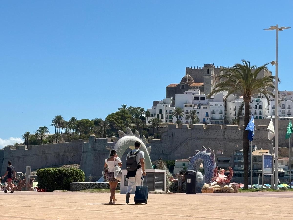Imagen de dos turistas con maletas en Peñíscola.