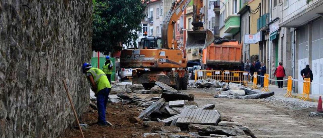 Ayer los operarios levantaron la acera paralela al muro bajo la supervisión del arqueólogo. // Iñaki Abella