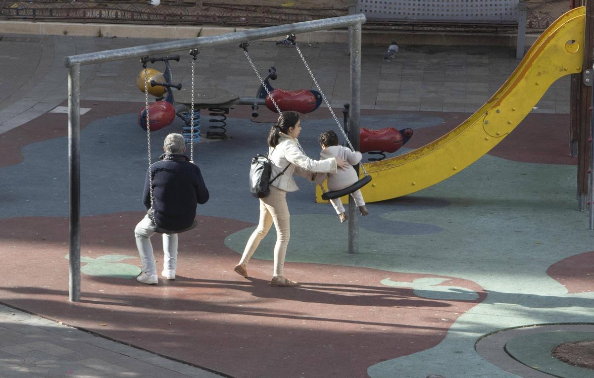 Una familia, en un parque infantil de Alzira, en una imagen de archivo.