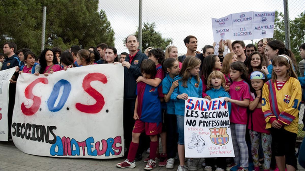 Miembros de las diversas secciones del Barça que sufrirán recortes muestras sus pancartas reivindicativas en los alrededores del Camp Nou