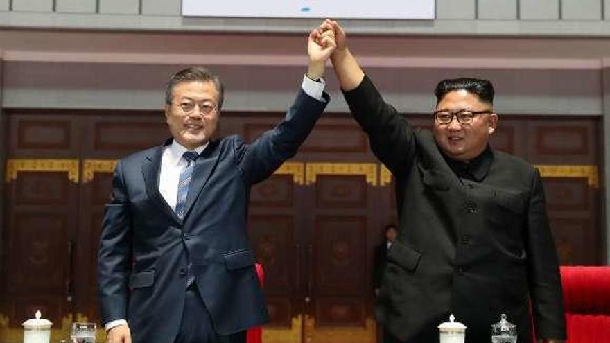 Moon y Kim (dcha.) saludan al numeroso público congregado en un acto en el May Day Stadium de Pyongyang. // Reuters