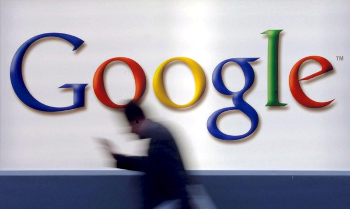 Un home passa davant del logotip de Google.