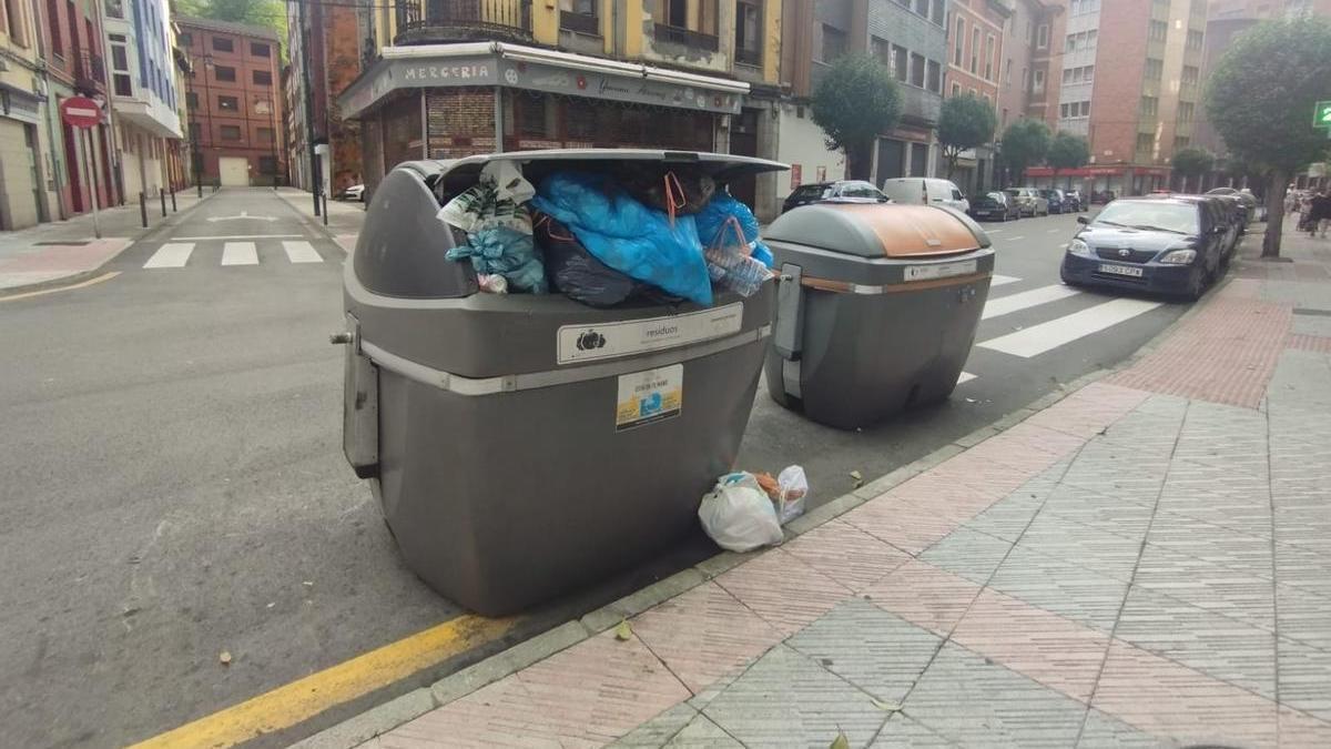 Un contenedor de la calle Dorado, este domingo,  a rebosar de basura.