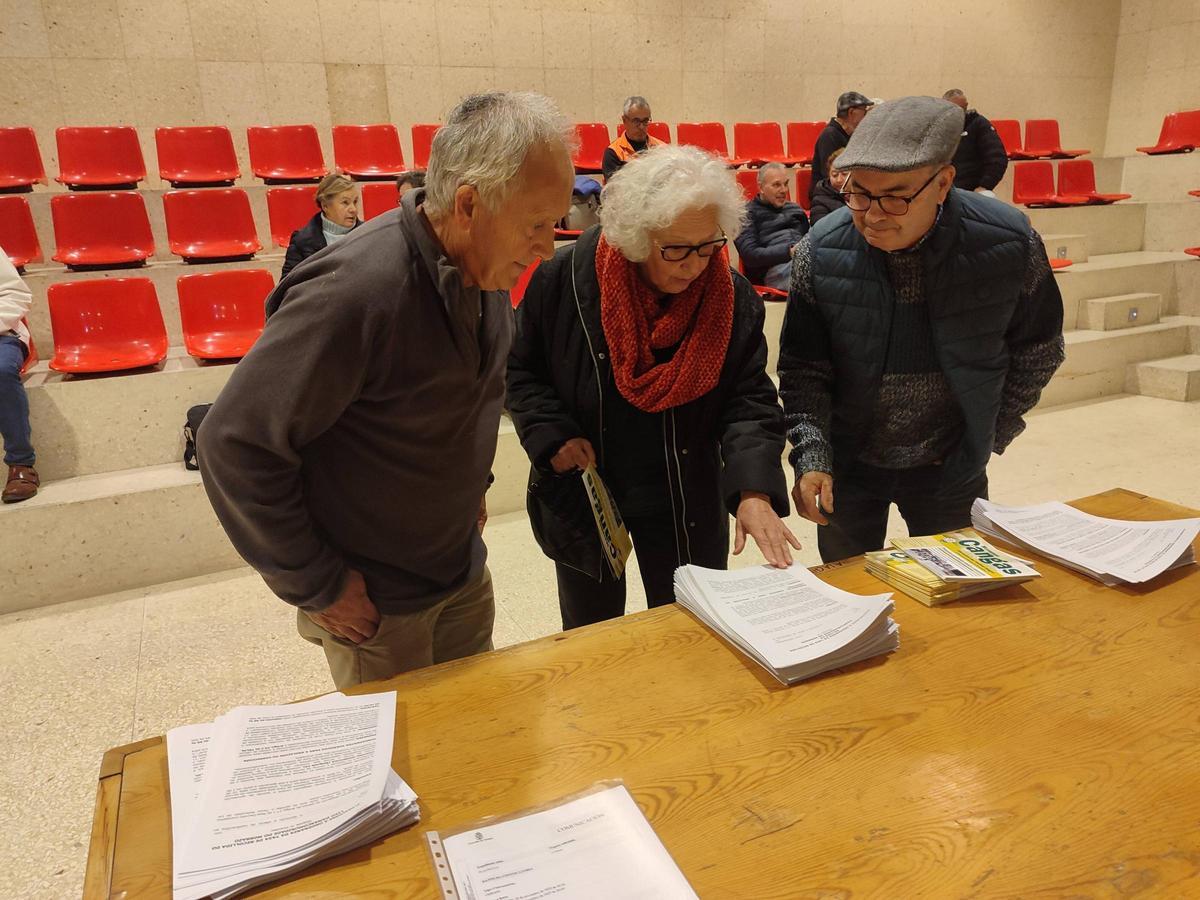 Asistentes ojeando los modelos de alegaciones de AV y el panfleto "Móvenos Cangas" al lado