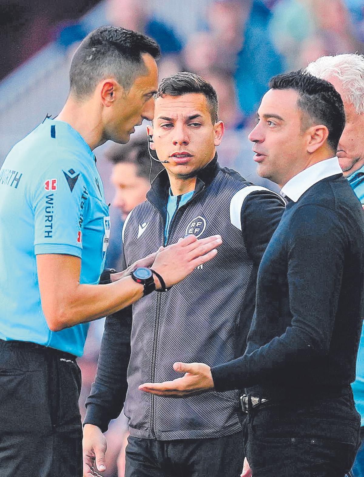 Xavi dialoga amb l'àrbitre José María Sánchez Martínez durant el partit de diumenge