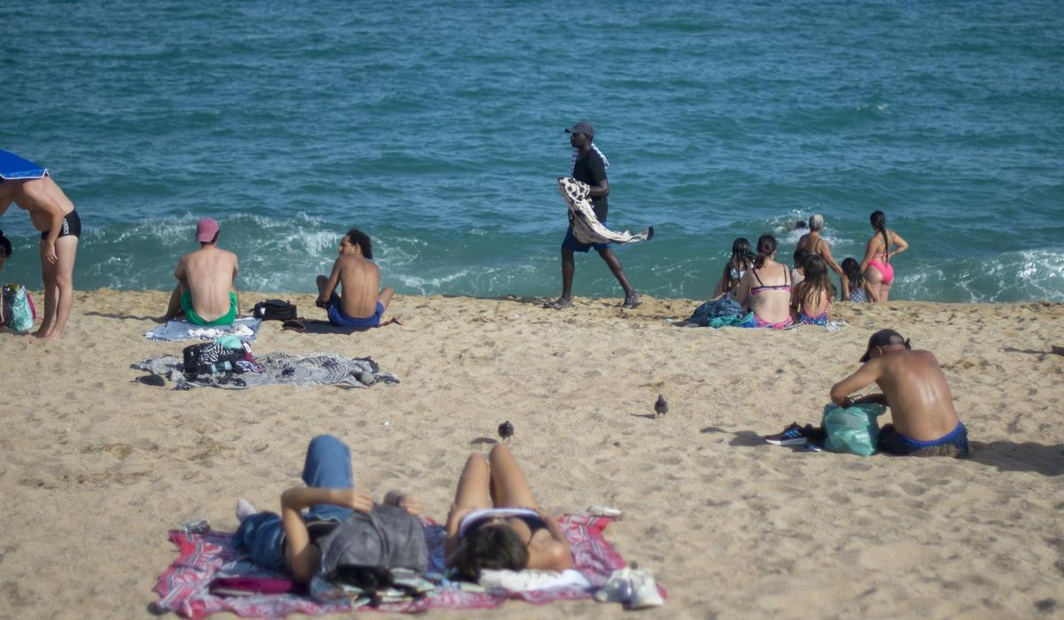 Un vendedor ambulante en la playa del Pont del Petroli de Badalona, este verano