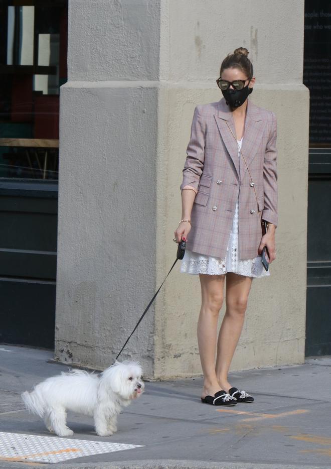 Olivia Palermo paseando a su perro por Nueva York con americana larga de cuadros y minivestido