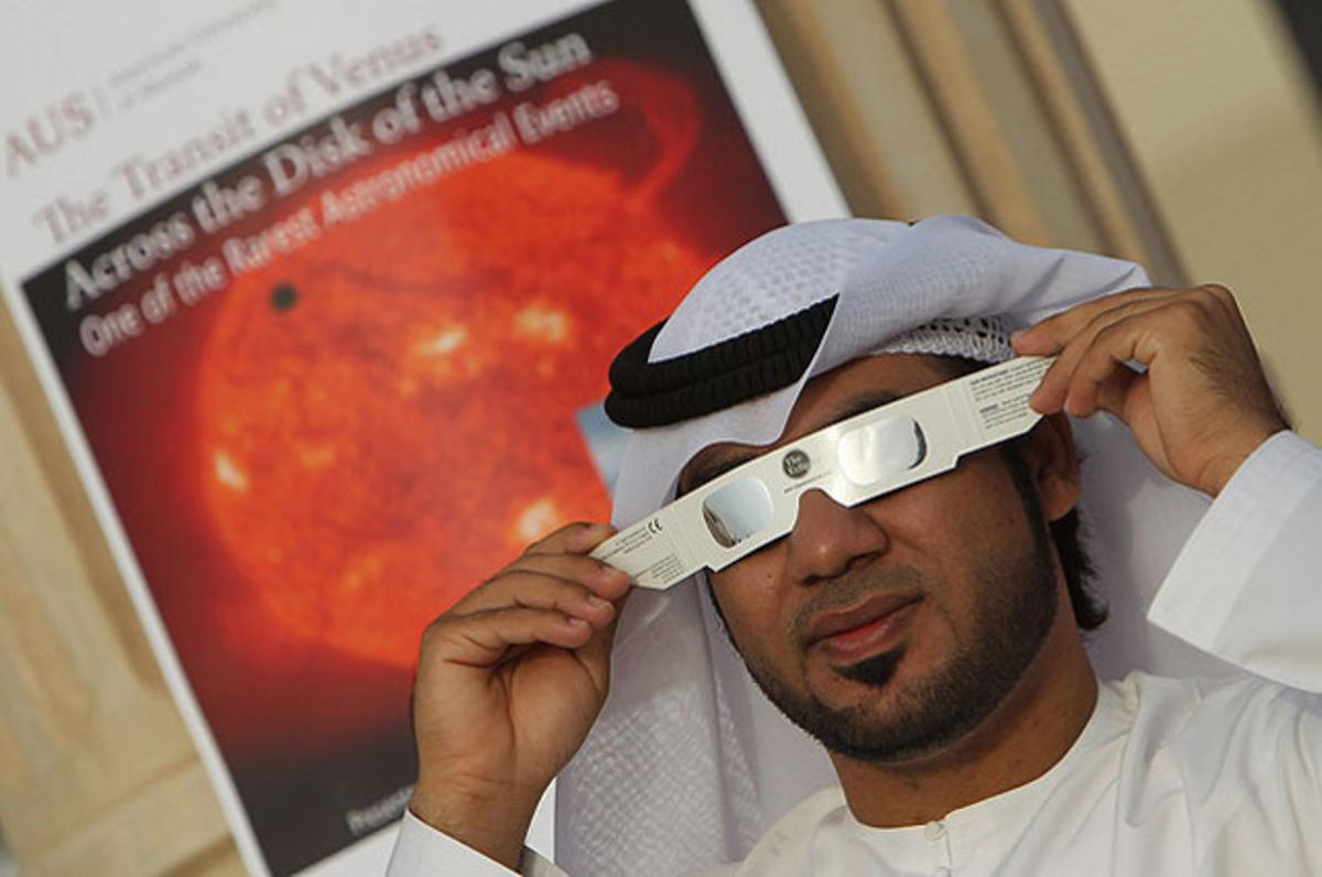 Un home utilitza ulleres amb filtres solars durant una reunió organitzada per un grup astronòmic de Dubai i la Universitat Americana de Sharjah, per observar el trànsit del planeta Venus entre la Terra i el Sol, a Sharjah (Emirats Àrabs Units).