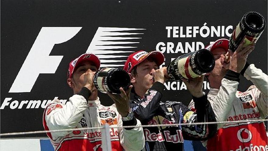 Vettel, en el centro, bebe champán junto al segundo y tercer clasificados, Lewis Hamilton y Jenson Button.