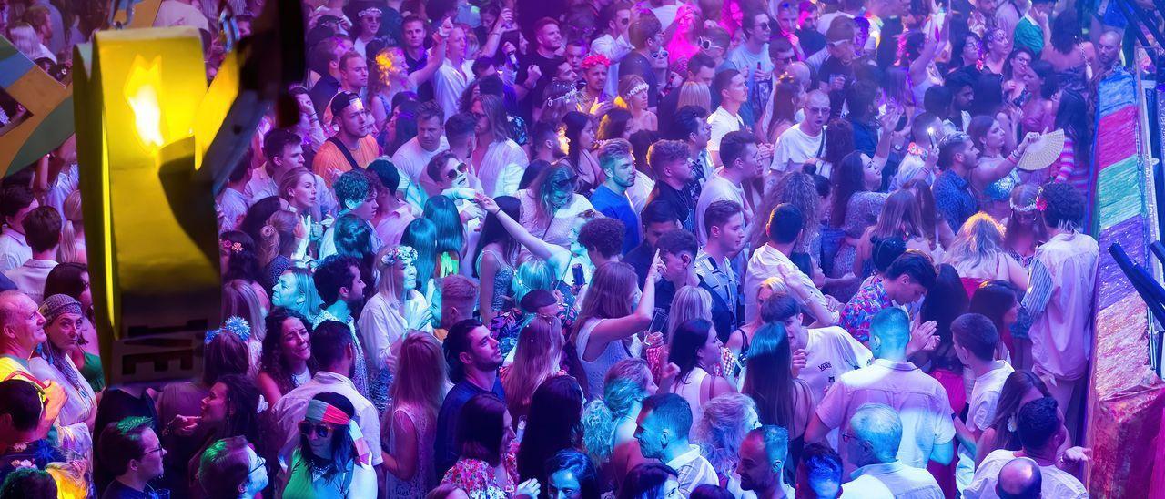 Decenas de personas asisten a una fiesta en una discoteca.