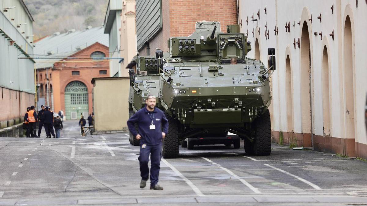 Un trabajador de Santa Bárbara, junto a un blindado 8x8, en el recinto de la compañía en Trubia (Oviedo).