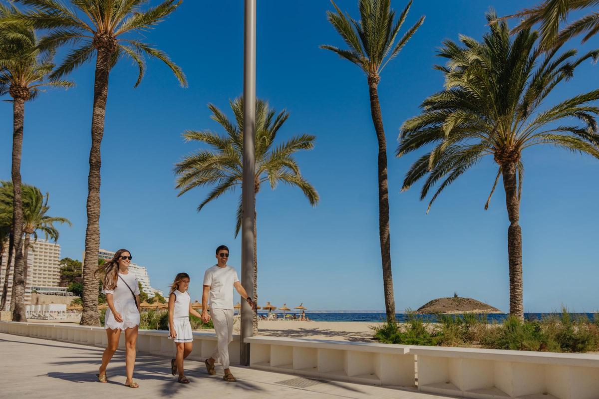 Una familia de turistas camina por el paseo marítimo de Magaluf.