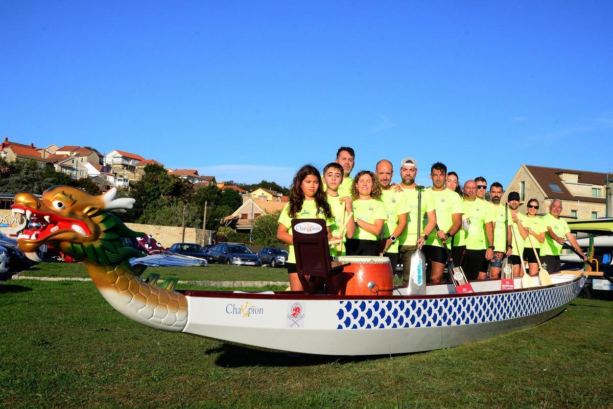 Los palistas de Aldán posan en tierra con su flamante embarcación en el muelle de la parroquia canguesa.