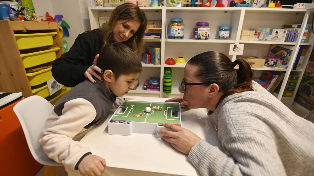 Miguel jugando con su madre (a la dech.), con la ayuda de Tania.
