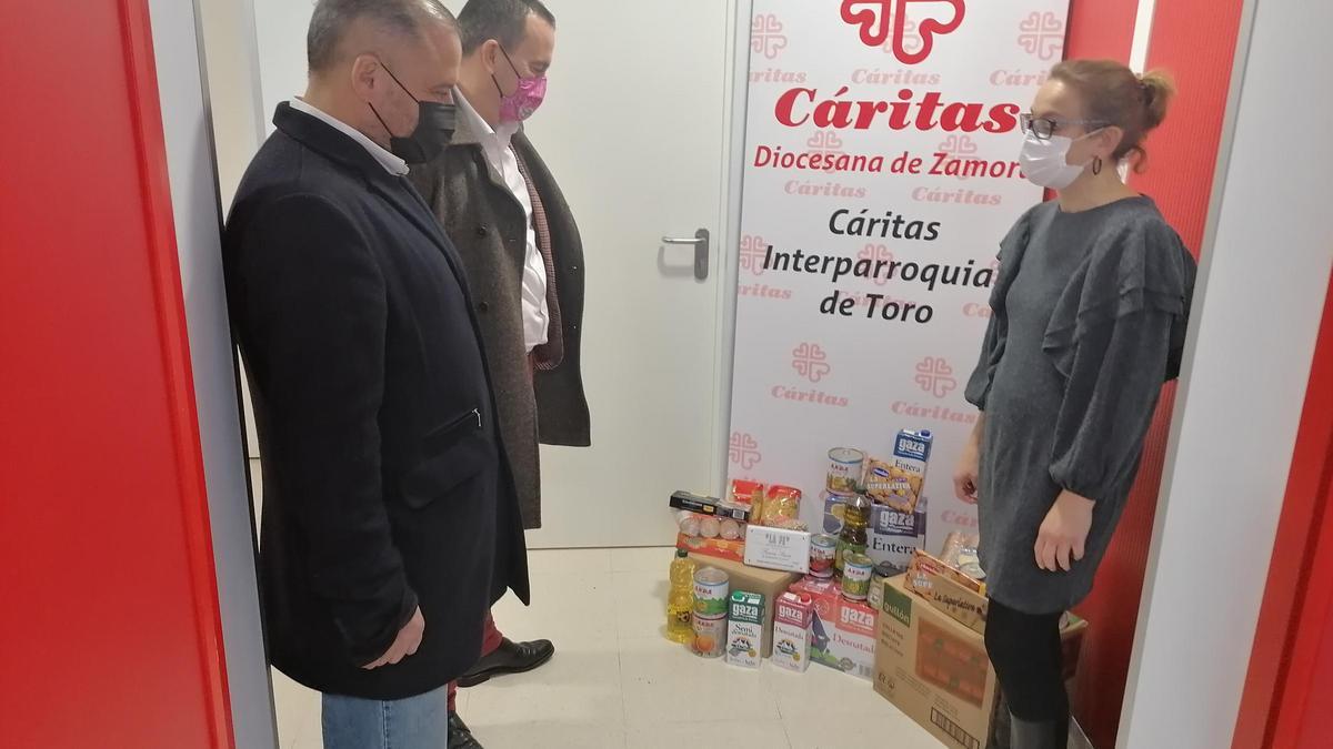 Requejo, Nalda y una trabajadora de Cáritas posan con los alimentos donados