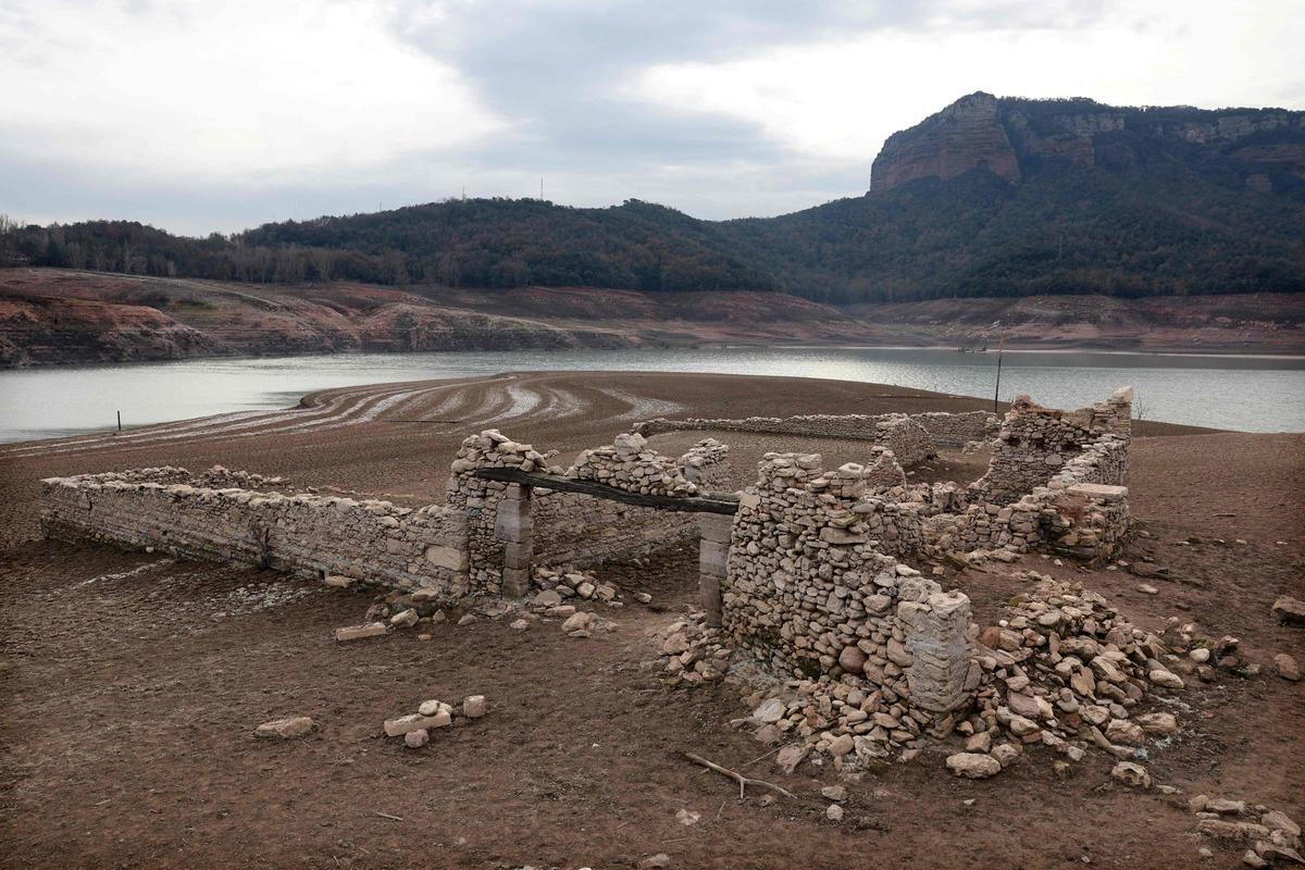 Esta fotografía tomada el 15 de enero de 2024 muestra el suelo seco junto al embalse de bajo nivel de Sau, en la provincia de Girona en Cataluña. Cataluña lucha contra una sequía histórica desde hace tres años y algunos residentes ya experimentan restricciones de agua en su vida diaria