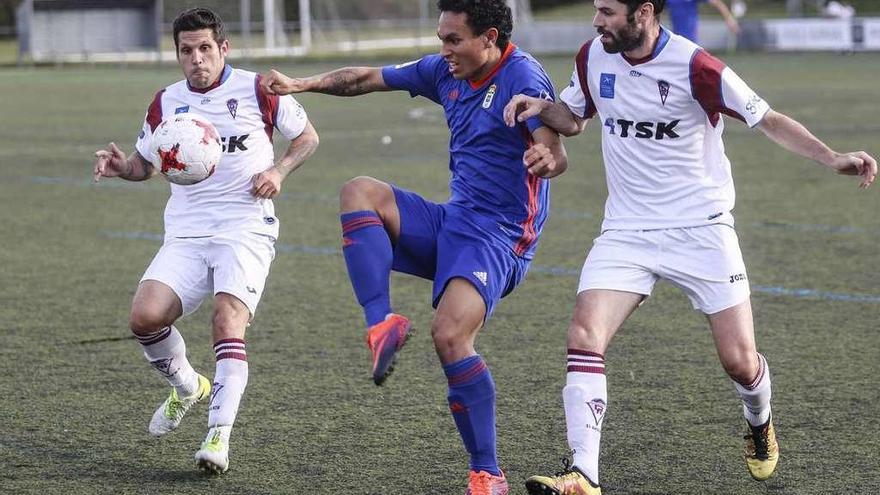 Steven, del Vetusta, protege la pelota rodeado de dos jugadores del Roces.