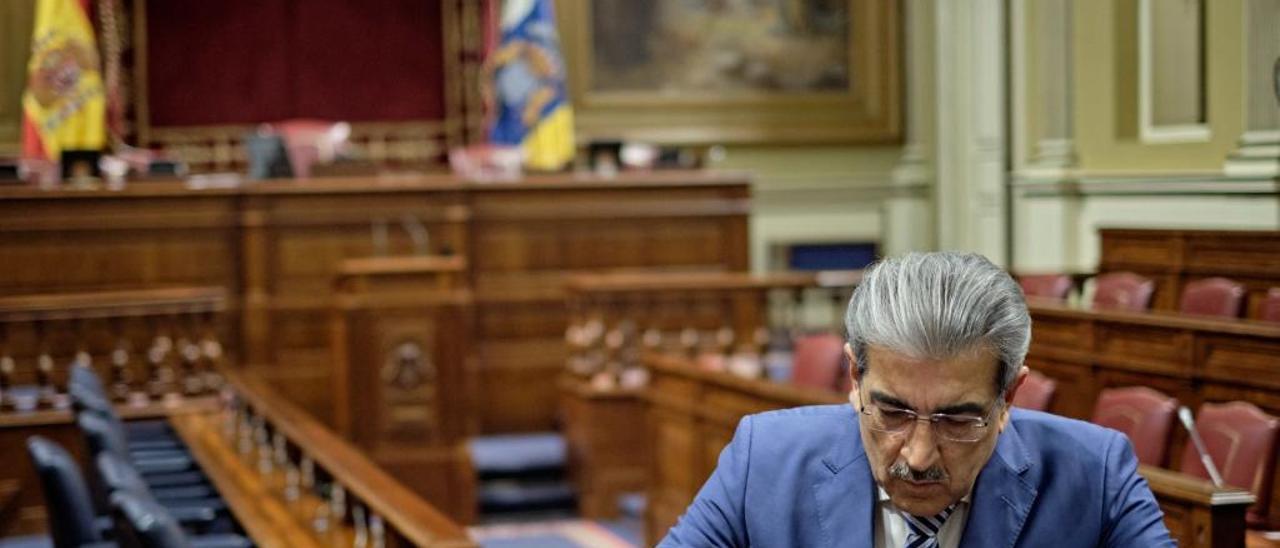 Román Rodríguez consulta su móvil en el hemiciclo del Parlamento.