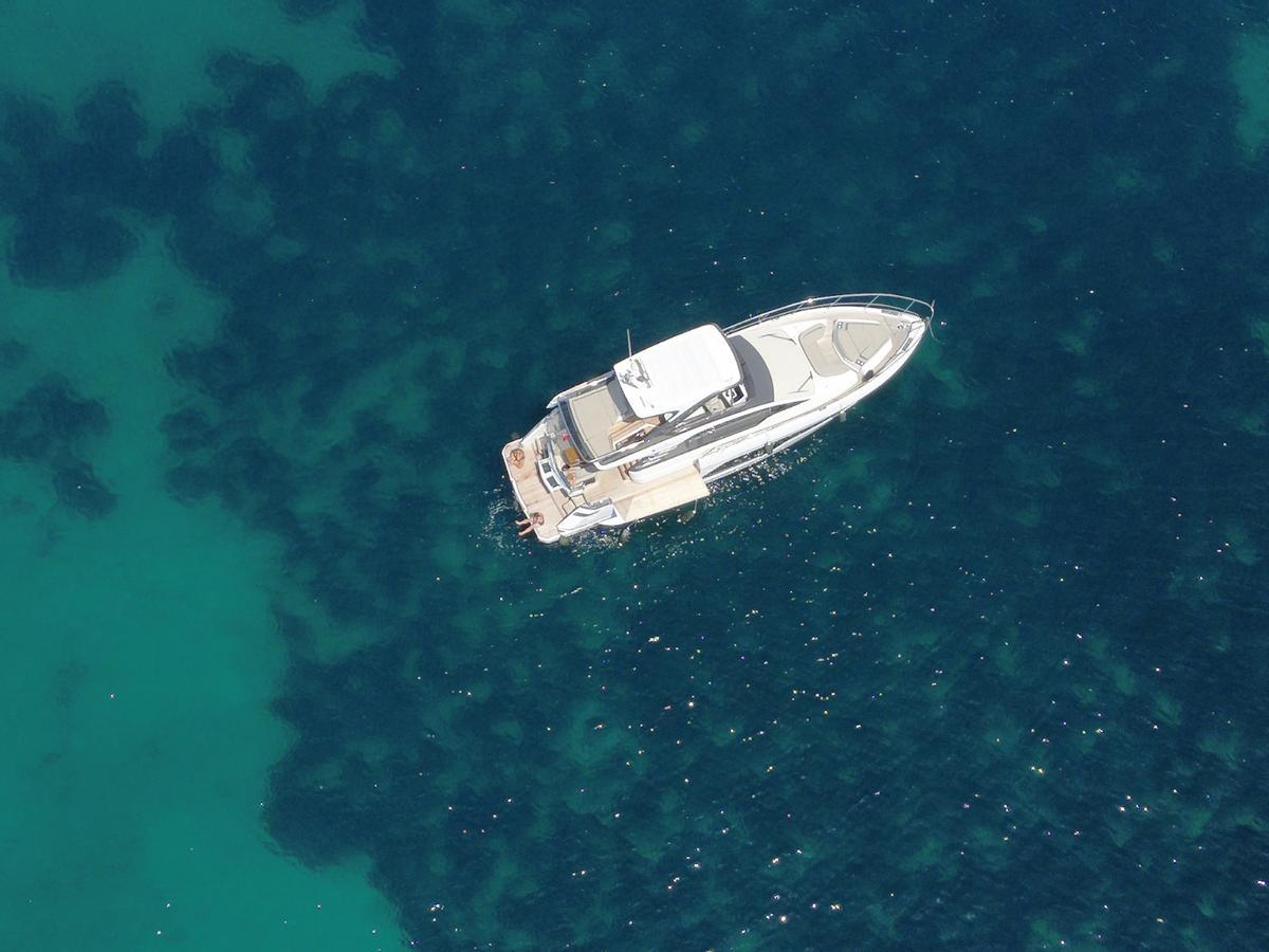 La embarcación, fondeada sobre la pradera de posidonia