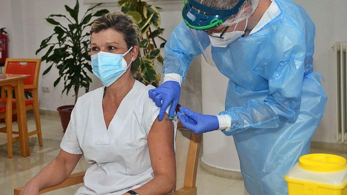 Una enfermera, inoculando la vacuna  a una sanitaria.