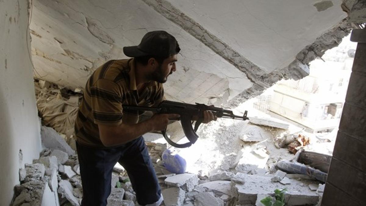 Un soldado del Ejército Libre de Siria sostiene un rifle en el interior de una vivienda, el sábado, en el barrio de Saladino, en Alepo.
