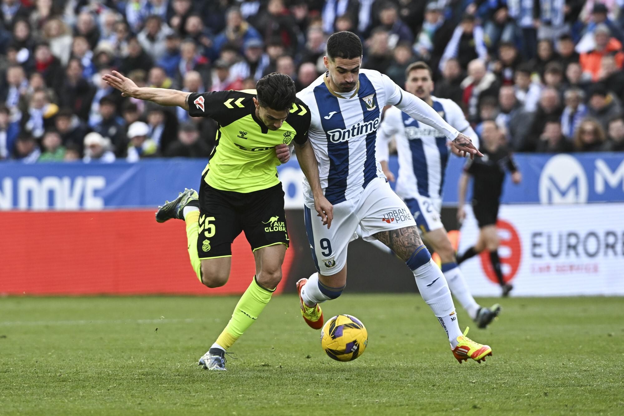 LEGANÉS (MADRID), 16/03/2025.- Marc Bartra (i), del Betis, lucha por el balón con ;Miguel de la Fuente, del Leganés, durante el partido de LaLiga Leganés-Betis este domingo en el estadio municipal Butarque en Leganés (Madrid). EFE/ Fernando Villar