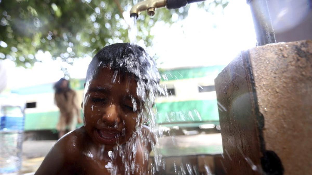 Un niño se refresca en un caluroso día en Karachi, Pakistán.