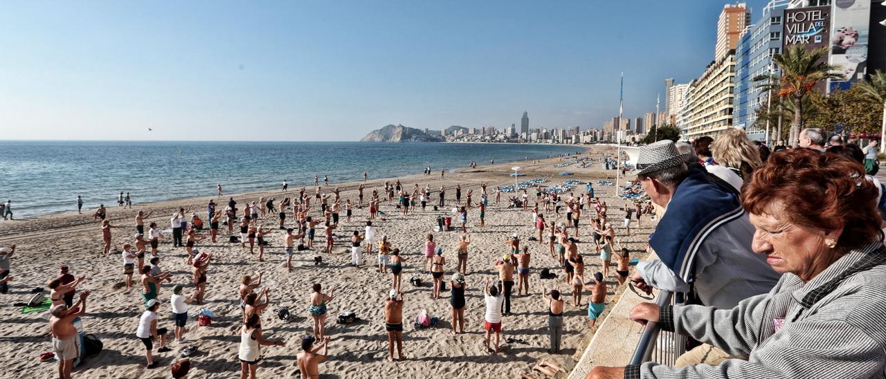 Turistas del Imserso haciendo gimnasia en Benidorm a primera hora de la mañana en una imagen del invierno de 2019