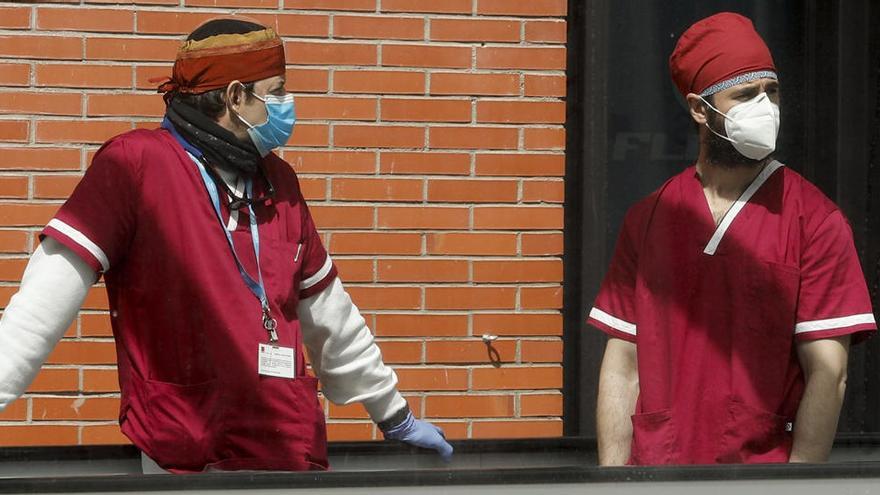 Dos sanitarios se toman un descanso en el pabellón 9 del hospital provisional de Ifema.