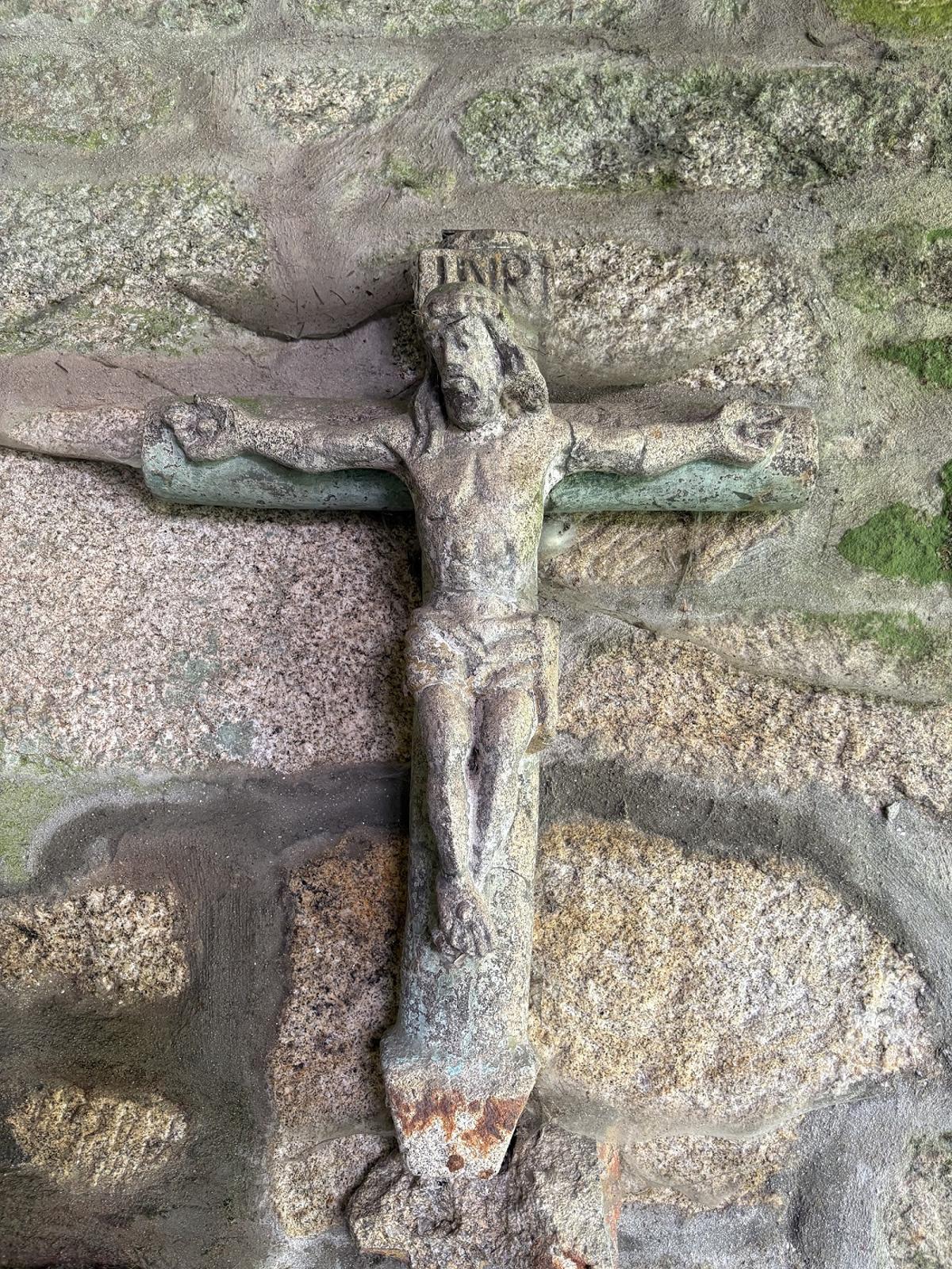 La cruz del antiguo cruceiro colgada de una de las paredes de la casa rectoral de Cesantes.