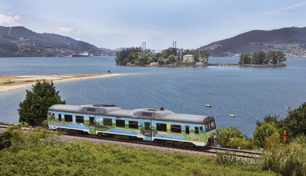 Uno de los Trenes Turísticos de Galicia a su paso por la Ría de Vigo con la isla de San Simón y Rande al fondo.