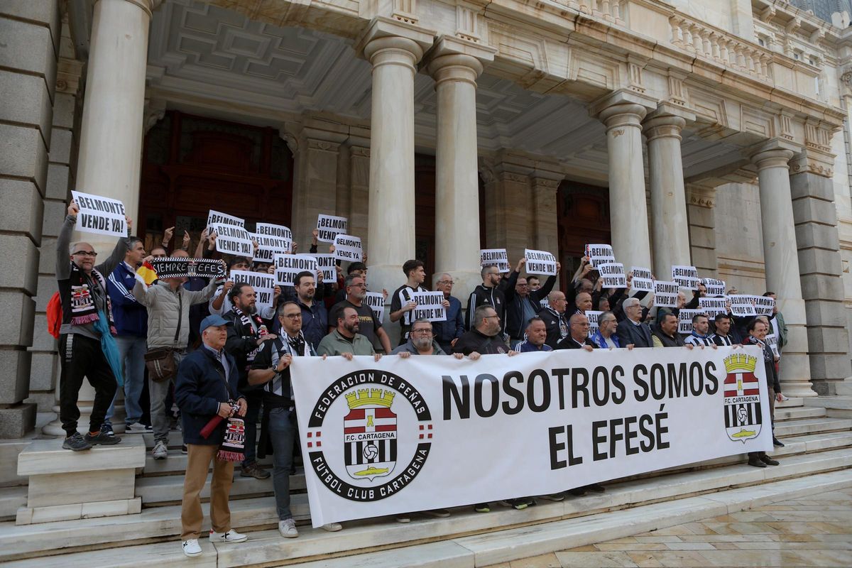 Aficionados albinegros posan tras la pancarta de la Federación de Peñas