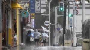 La gente camina a lo largo de Kokusai-dori bajo el fuerte viento y la lluvia del tifón Khanun en Naha, Prefectura de Okinawa, Japón, este 2 de agosto de 2023.