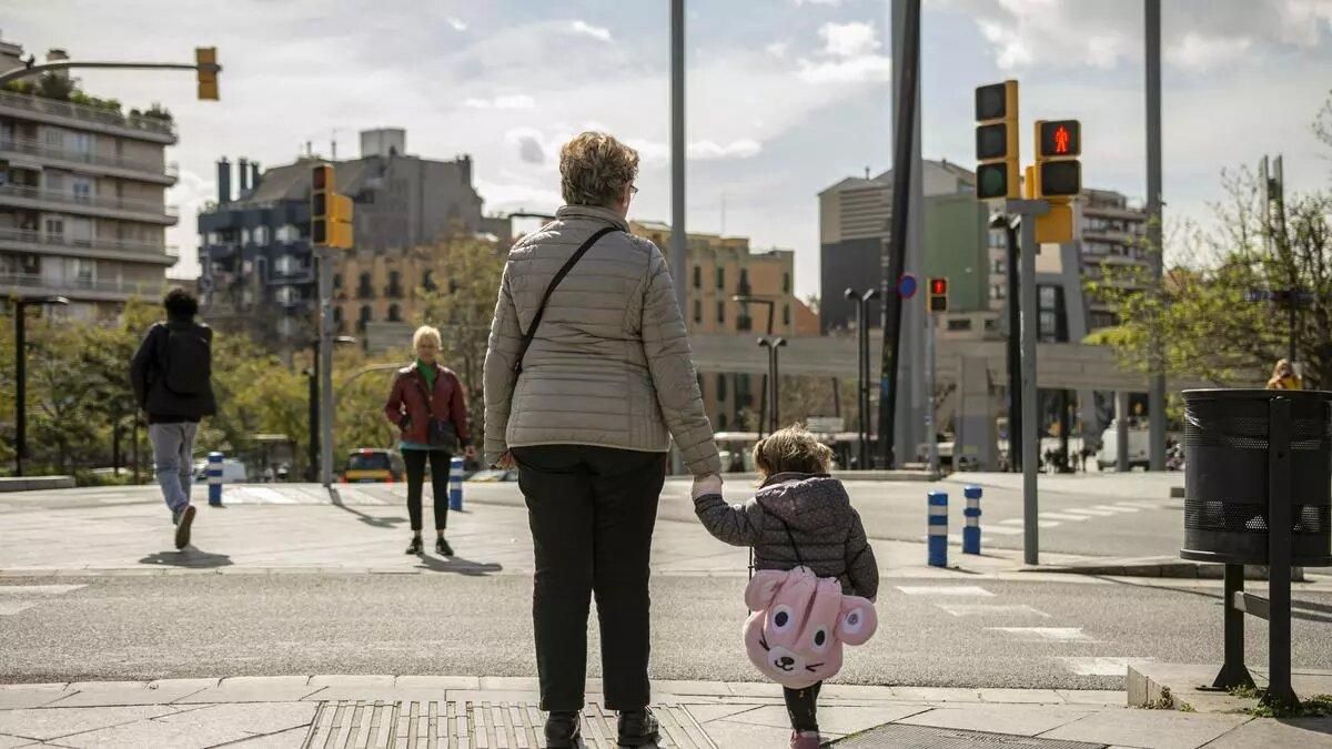 Una abuela pasea con su nieta, en edad de prescolar