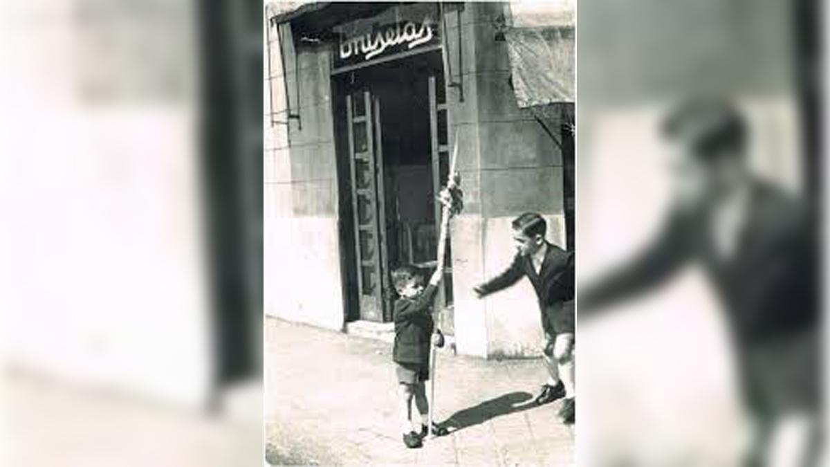 Dos niños con un palmón ante la Granja Bruselas cuando todavía estaba en la calle de Aragó