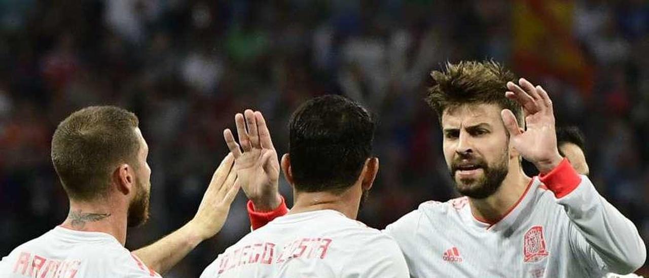 Piqué felicita a Diego Costa ante Sergio Ramos, ayer, en Sochi.