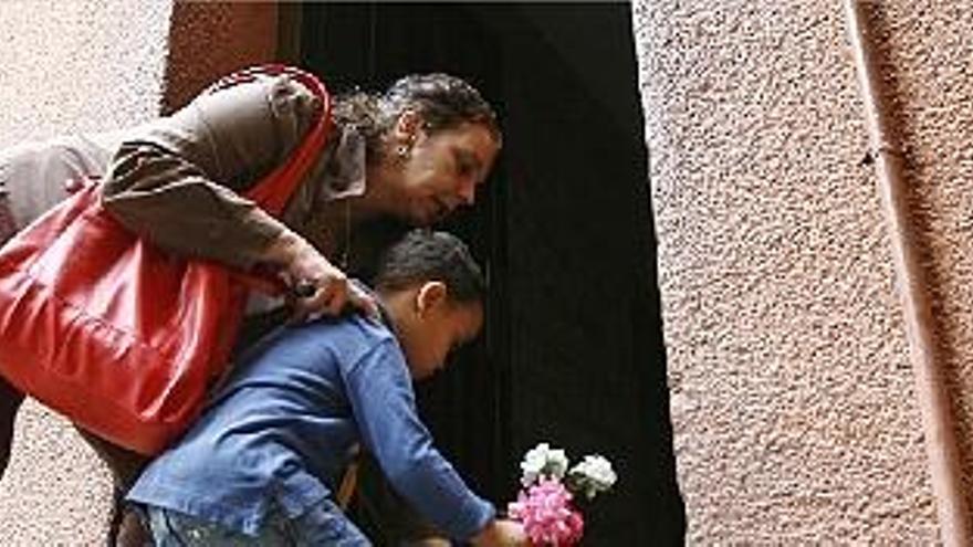 Una mujer y un niño dejan unas flores en el lugar de la tragedia.
