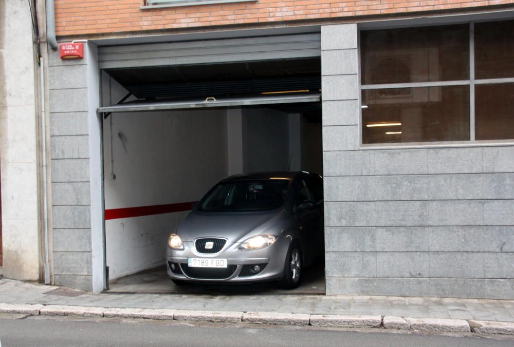 Un vehicle de la policia sortint del garatge del bloc on s'ha fet part de l'operatiu a Figueres