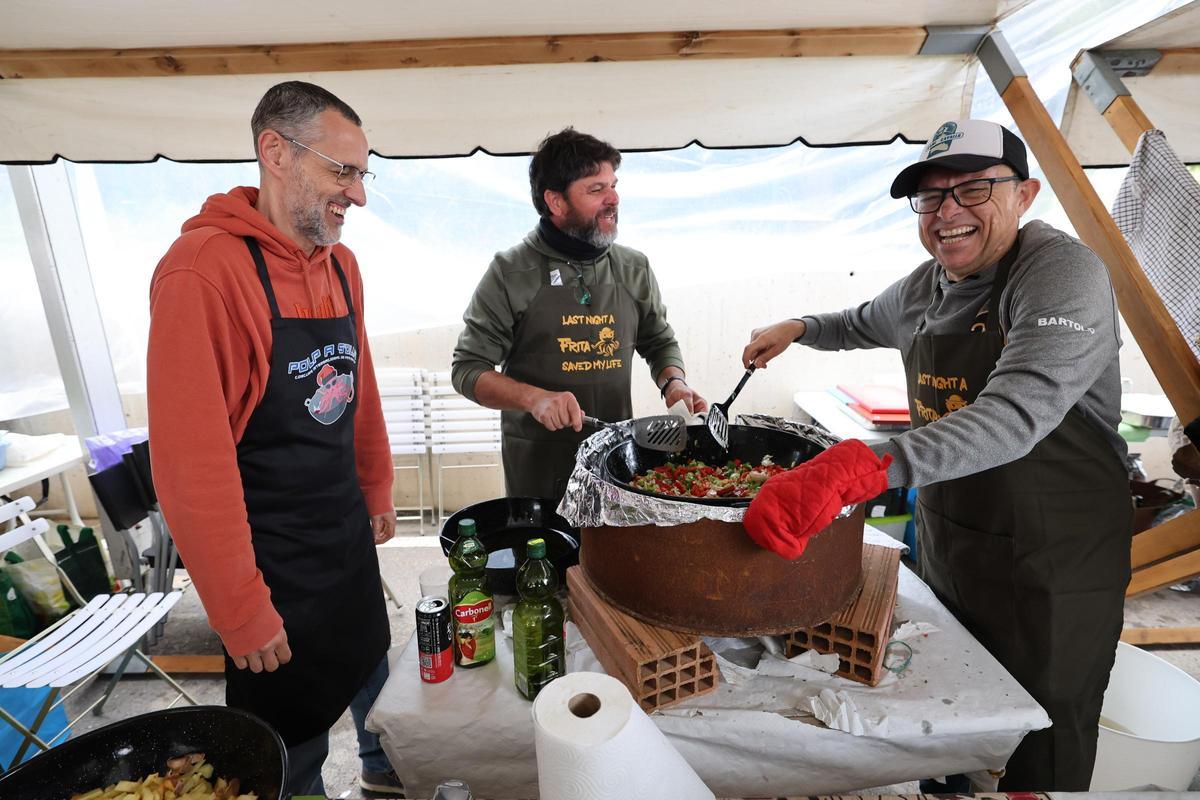 Uno de los grupos participantes en el concurso del 'Polp a s’olla! IV Concurso de Frita de Polp', sonríen mientras cocinan.