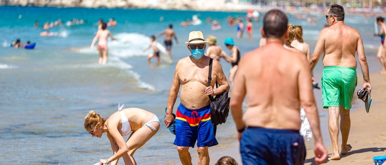 Bañistas con mascarilla en la playa, en una imagen tomada el pasado verano.