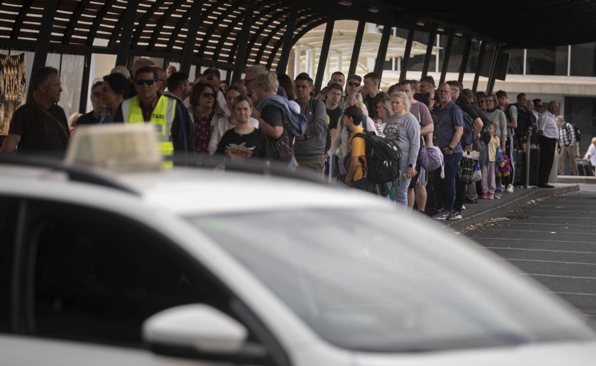 Colas para coger un taxi o una guagua por fuera del aeropuerto Tenerife Sur.