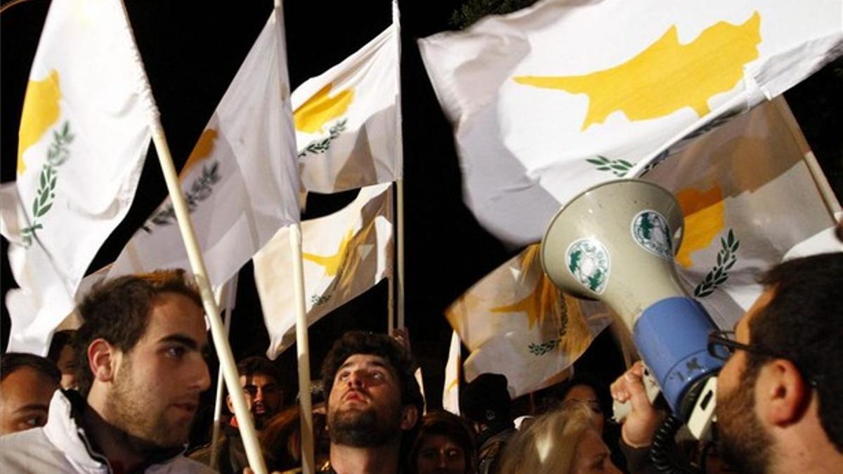 Ciudadanos chipriotas se manifiestan frente al Parlamento de Chipre en Nicosia.