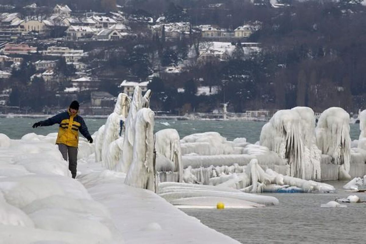 Un home camina sobre l’embarcador congelat del llac Ginebra, a Suïssa. Les gèlides temperatures que es fan notar a tot Europa han arribat a mínimes de -34º C en aquest país, on la mitjana és de -10º C, però amb sensacions tèrmiques d’entre -18º C i -25º C.