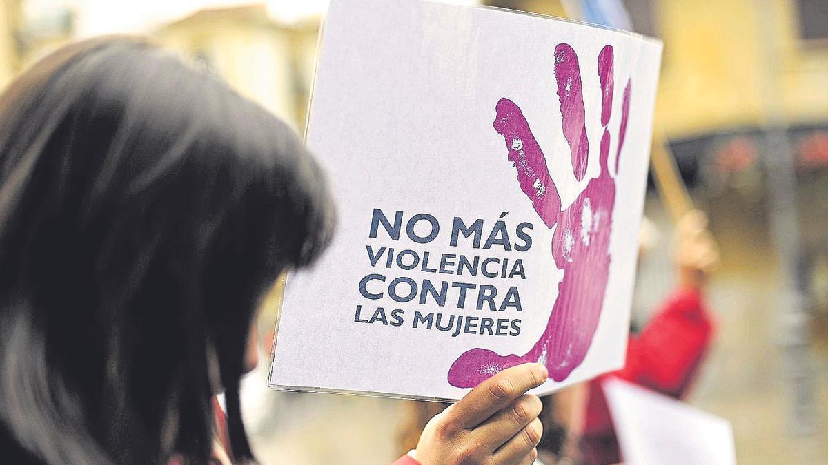 Una mujer muestra un cartel contra la violencia de género,