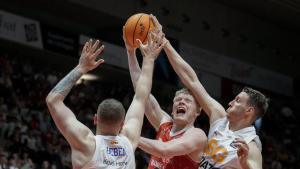 Knudsen, del Manresa, intenta lanzar a canasta entre dos jugadores del Girona. 