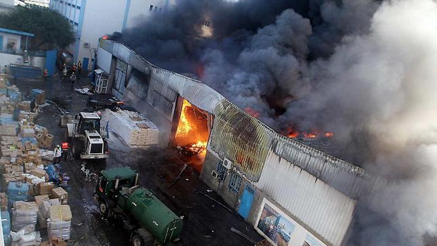 El almacén central de alimentos de Naciones Unidas, envuelto en llamas y humo tras el bombardeo efectuado por la artillería israelí