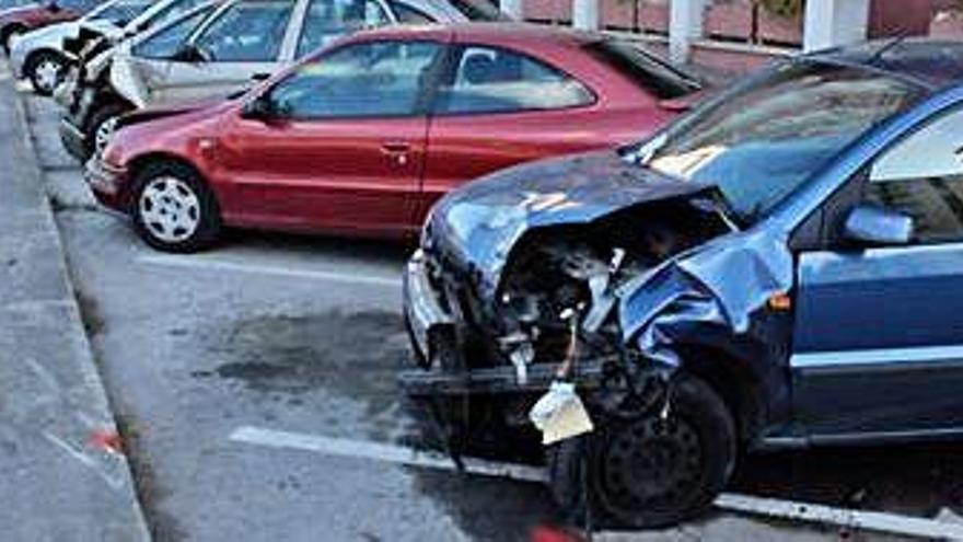 Destrosses en vehicles i mobiliari urbà. ?A l&#039;esquerra, els vehicles amb danys a la part davantera, destrossada a causa de l&#039;envestida del cotxe que va perdre el control. A la dreta, agents de la Guàrdia Urbana treballant sobre el terreny en la investigació del succés.