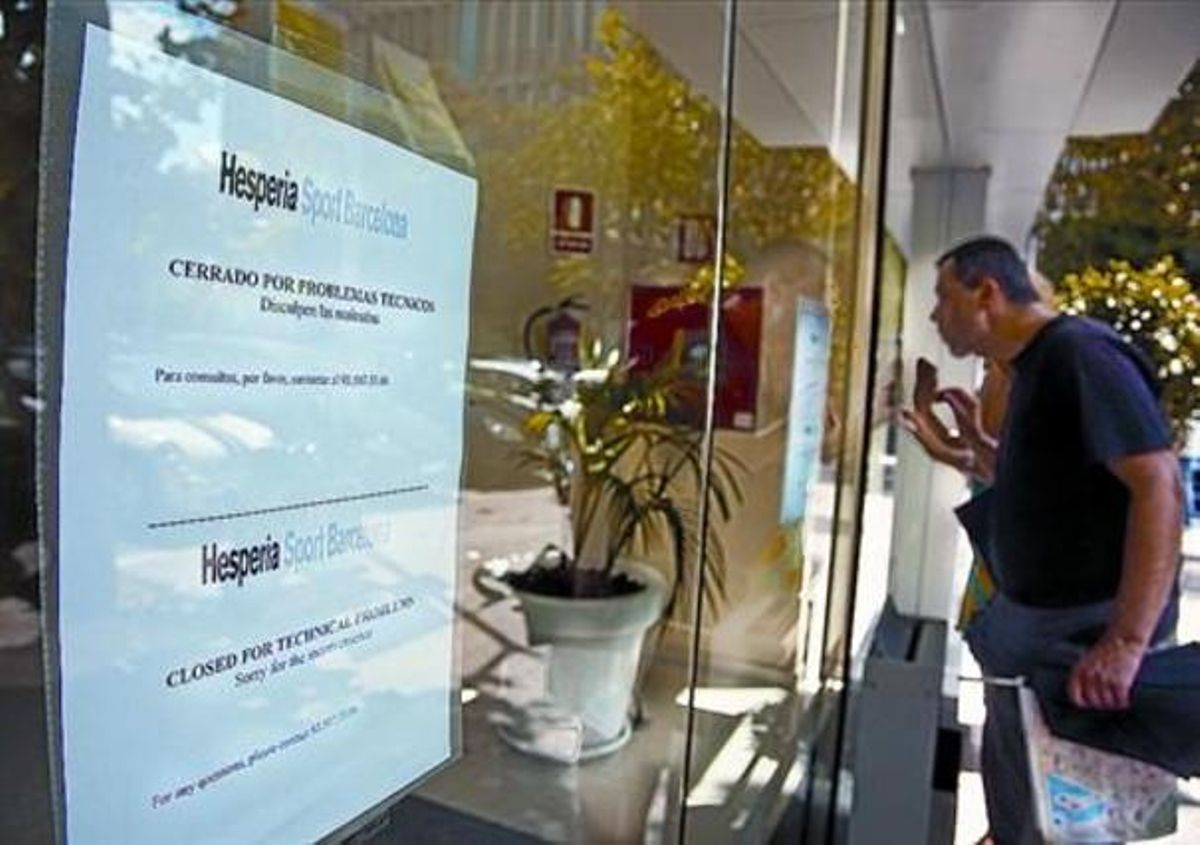 Una parella de turistes miren amb curiositat darrere les finestres de l’Hesperia Sport, precintat des de dijous. Una parella de turistes miren amb curiositat darrere les finestres de l’Hesperia Sport, precintat des de dijous.